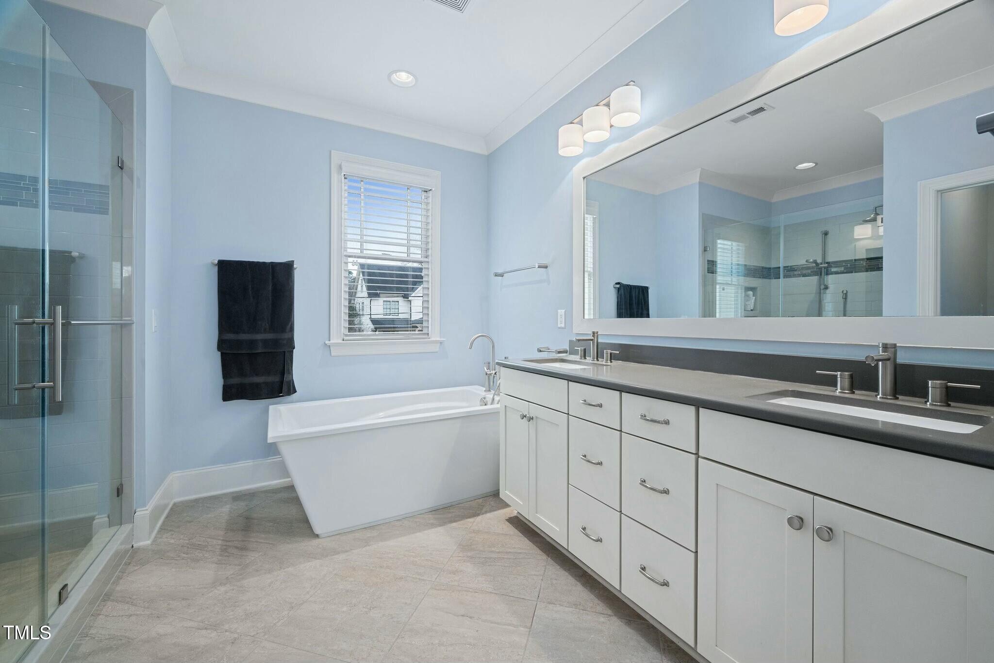 519 Peebles Street Raleigh, NC 27608 - Photo 22 of 43 a spacious bathroom with a granite countertop sink a toilet a mirror and shower
