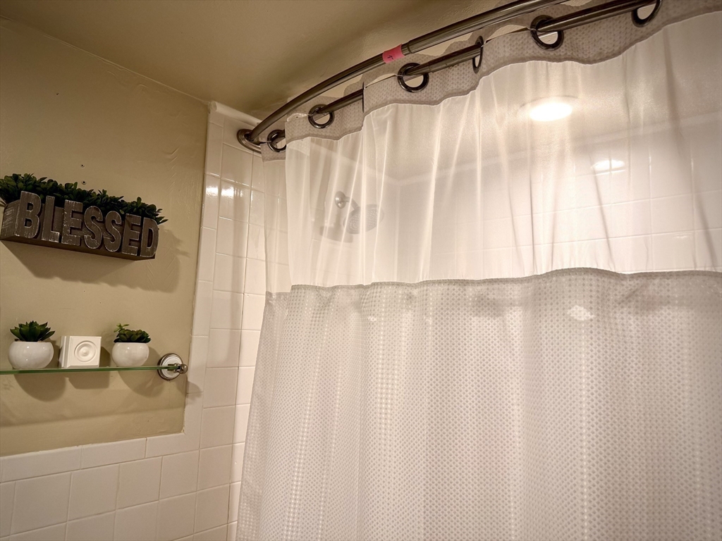 121 Tremont Street, Unit B1 Boston, MA 02135 - Photo 14 of 20 a bathroom with a shower and a tub sink