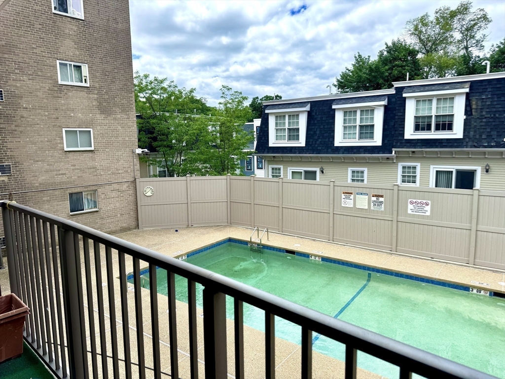 121 Tremont Street, Unit B1 Boston, MA 02135 - Photo 17 of 20 a backyard of a house with large trees and wooden fence