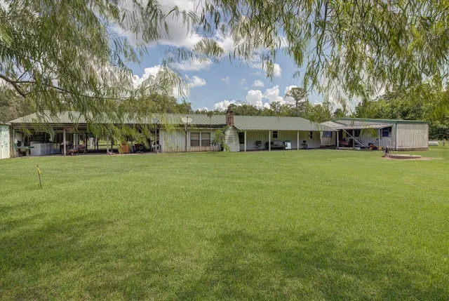 a view of a house with yard and sitting area
