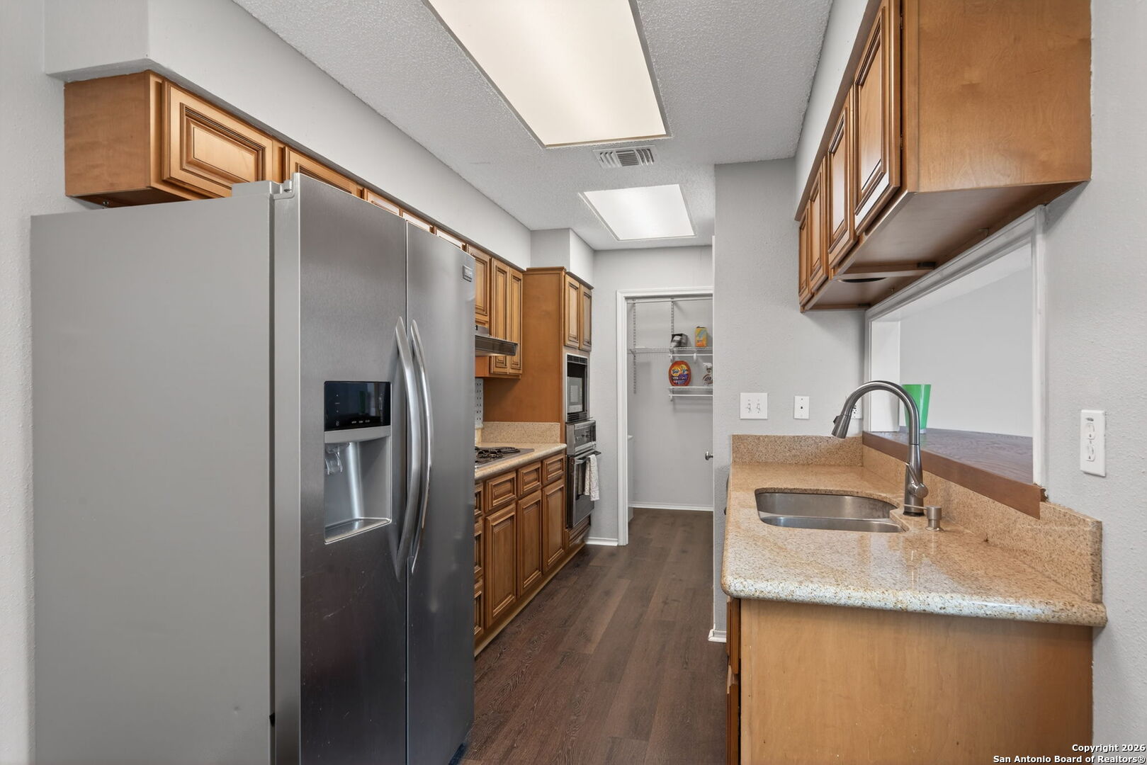 11001 Wurzbach Road, Unit 605 San Antonio, TX 78230 - Photo 13 of 47 a kitchen with stainless steel appliances granite countertop a refrigerator and a sink