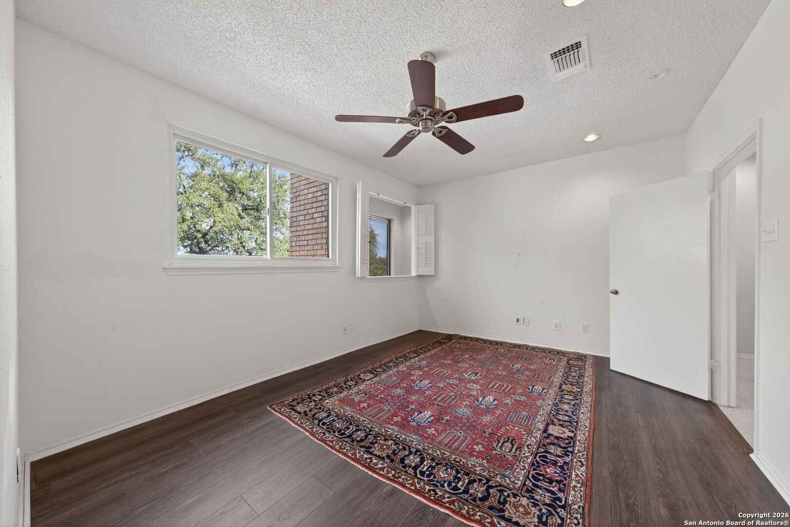 11001 Wurzbach Road, Unit 605 San Antonio, TX 78230 - Photo 22 of 47 a view of an empty room with a window and wooden floor