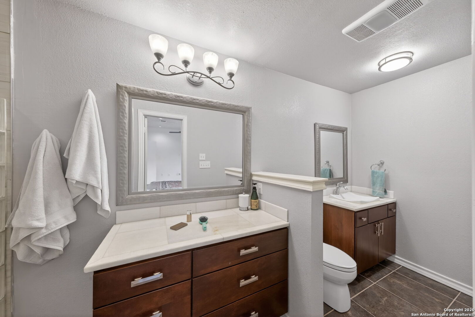 11001 Wurzbach Road, Unit 605 San Antonio, TX 78230 - Photo 25 of 47 a bathroom with a toilet sink and mirror
