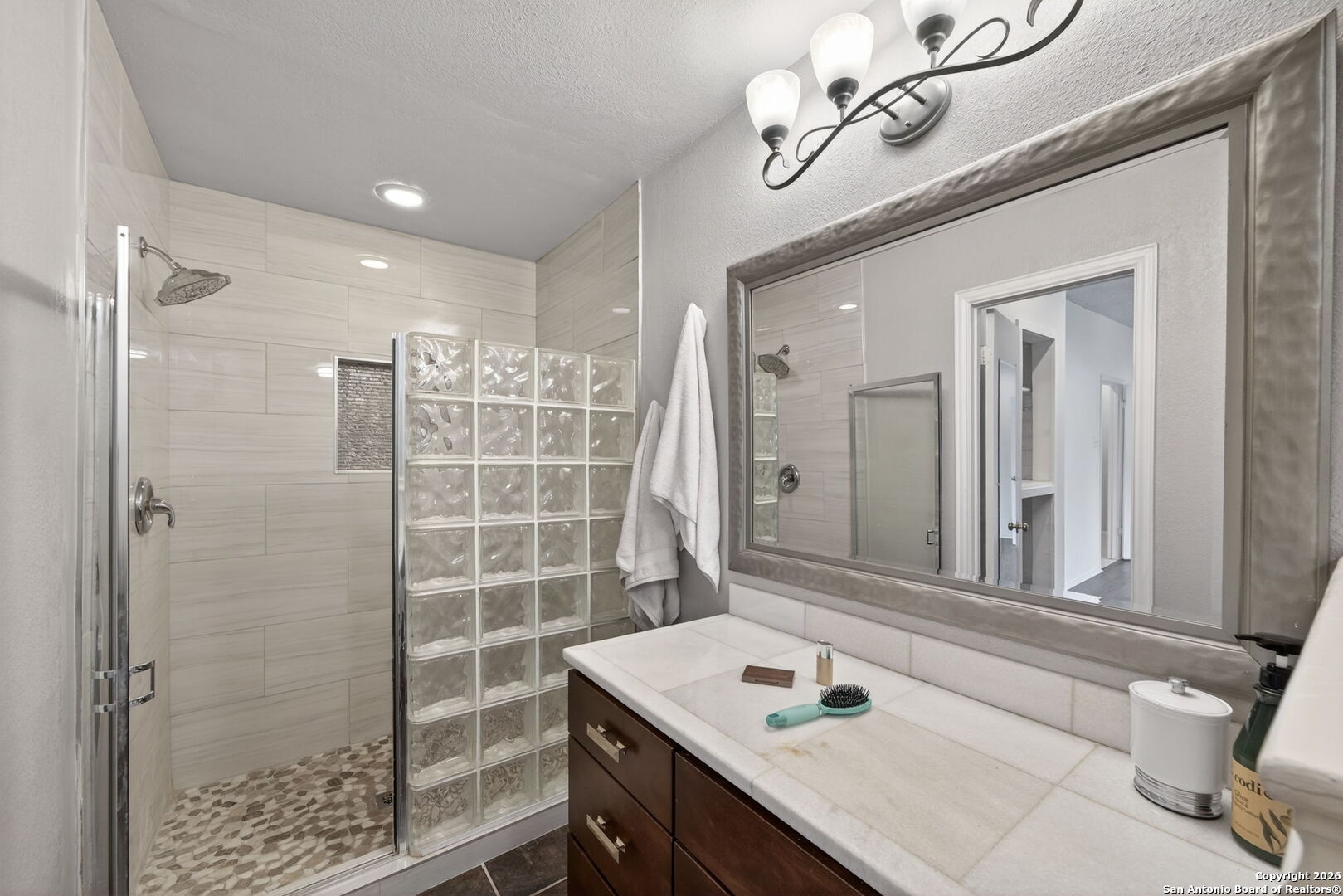 11001 Wurzbach Road, Unit 605 San Antonio, TX 78230 - Photo 26 of 47 a bathroom with a sink vanity granite shower and a mirror