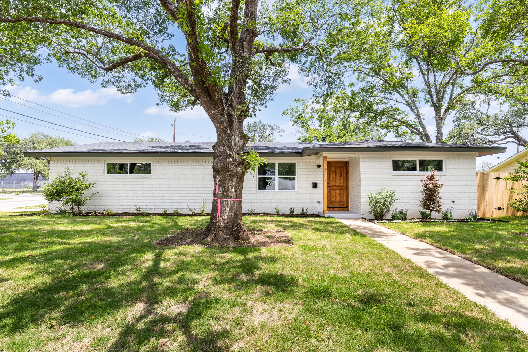 Single-story residence featuring a white brick exterior and dark roofline