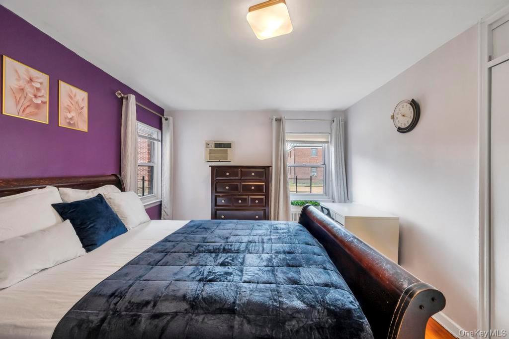 196-72 69th Avenue, Unit 1 Queens, NY 11365 - Photo 14 of 23 Bedroom with a wall unit AC and wood finished floors