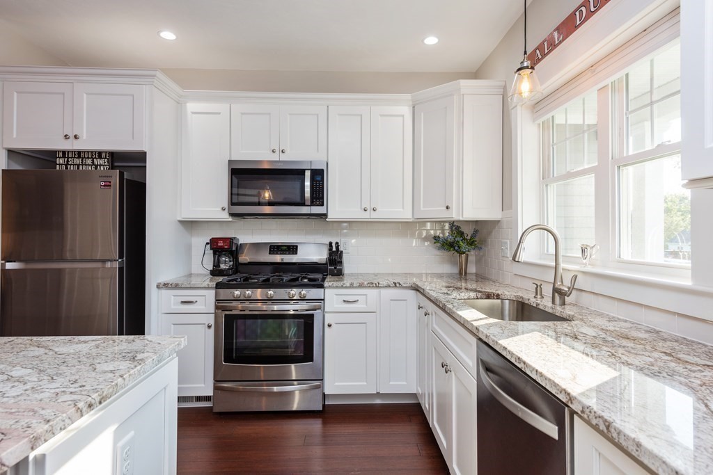 12 Ocean Pines Drive, Unit E Bourne, MA 02562 - Photo 8 of 28 a kitchen with granite countertop a stove a sink and a refrigerator