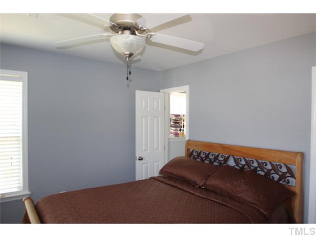 1137 South State Street Raleigh, NC 27601 - Photo 7 of 12 a bedroom with a bed and a chandelier