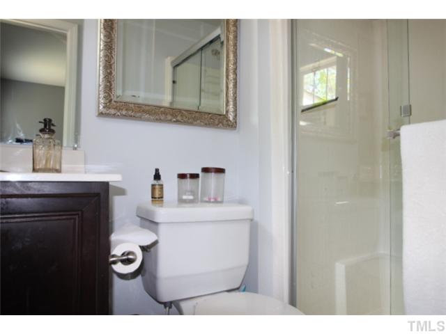 1137 South State Street Raleigh, NC 27601 - Photo 8 of 12 a bathroom with a toilet a sink and mirror