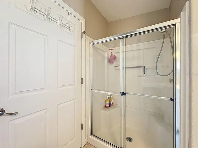 a spacious bedroom with a bed and a chandelier