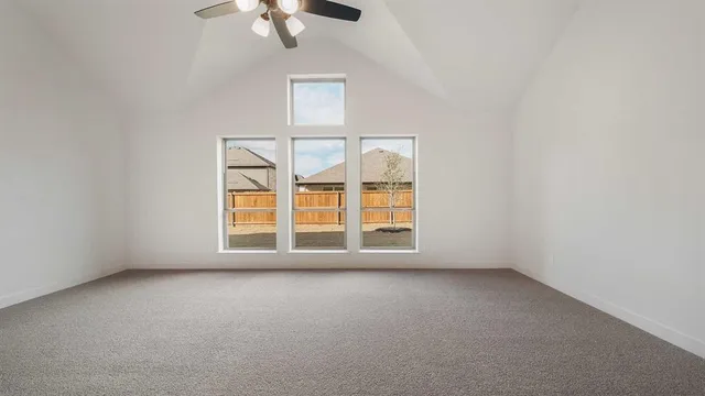 an empty room with chandelier fan
