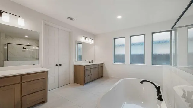 a bathroom with a bathtub sink and mirror