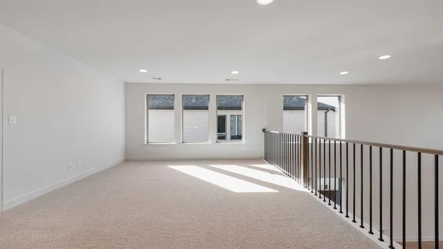 a view of a big room with wooden floor and windows