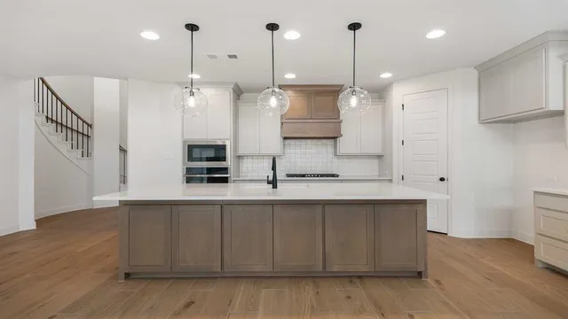 a large kitchen with kitchen island a sink stainless steel appliances and cabinets