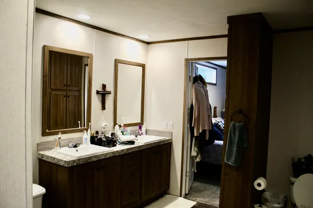 a bathroom with a sink and mirror with toilet