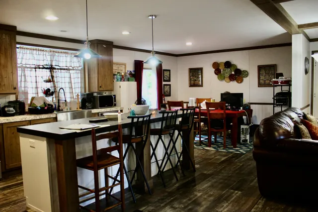 a group of people sitting in a living room with kitchen island furniture and a chandelier