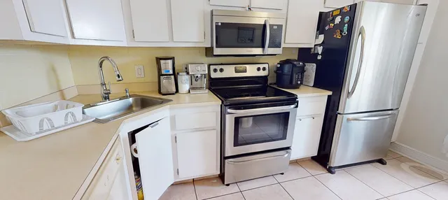 a kitchen with stainless steel appliances granite countertop a refrigerator sink and stove