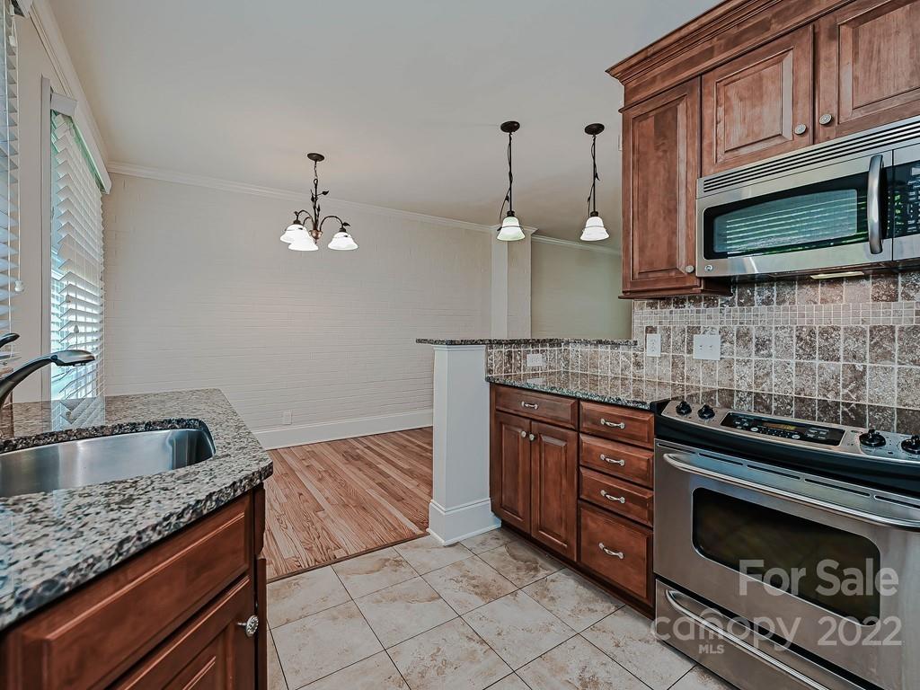4212 Randolph Road Charlotte, NC 28211 - Photo 11 of 23 a kitchen with stainless steel appliances granite countertop a sink stove and microwave
