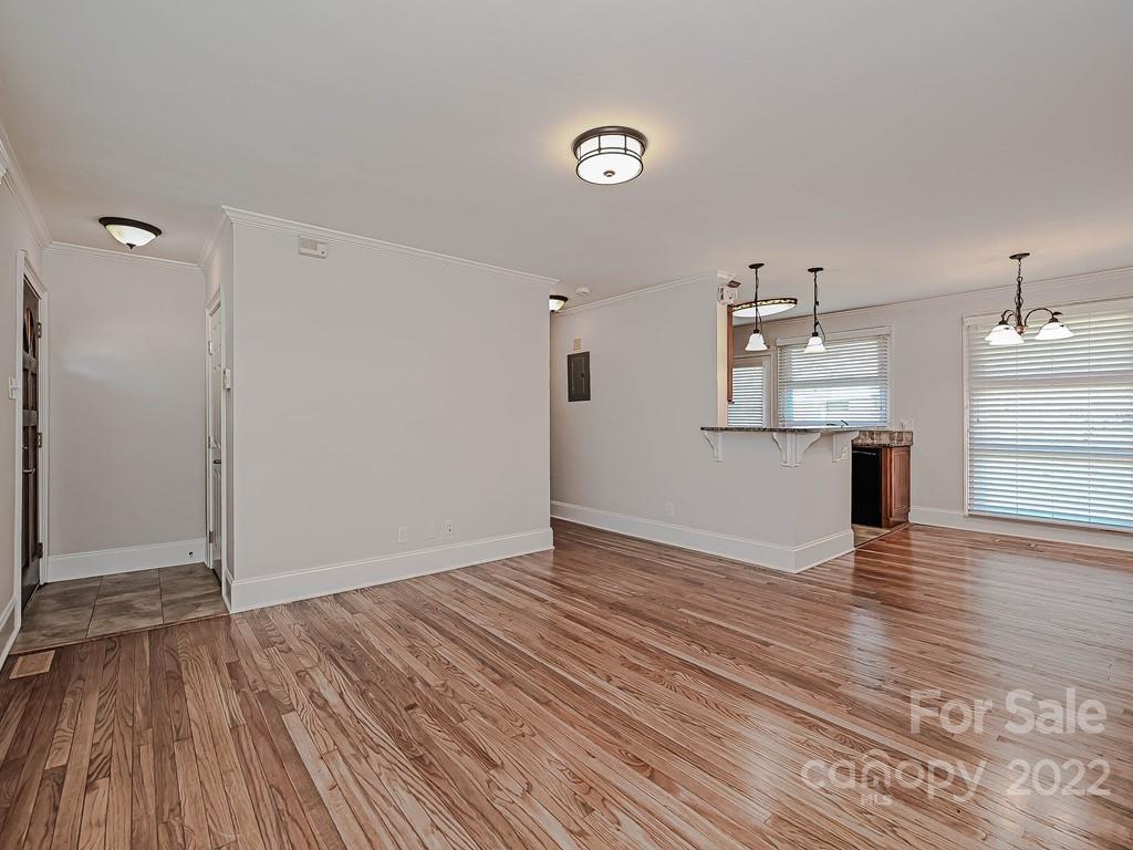 4212 Randolph Road Charlotte, NC 28211 - Photo 5 of 23 a view of empty room with wooden floor and kitchen view