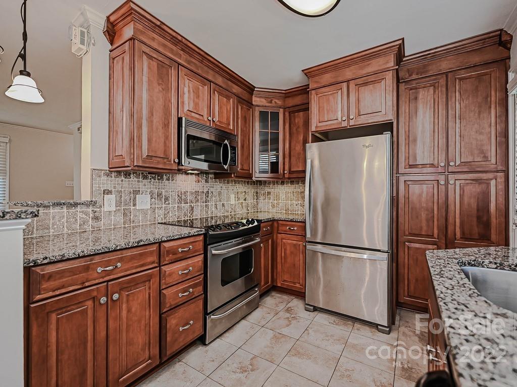 4212 Randolph Road Charlotte, NC 28211 - Photo 9 of 23 a kitchen with granite countertop a refrigerator stove and microwave