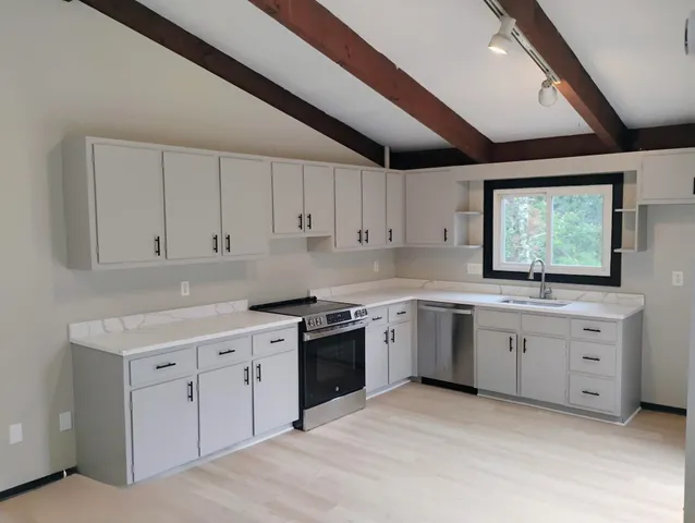 a kitchen that has a sink and a stove in it