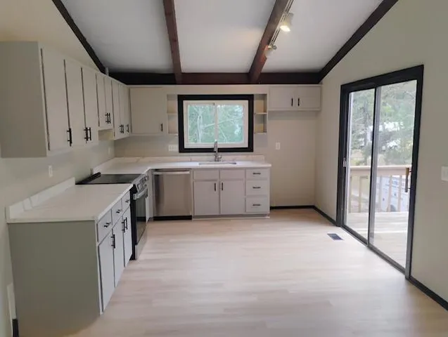 a kitchen with granite countertop a sink stainless steel appliances and cabinets
