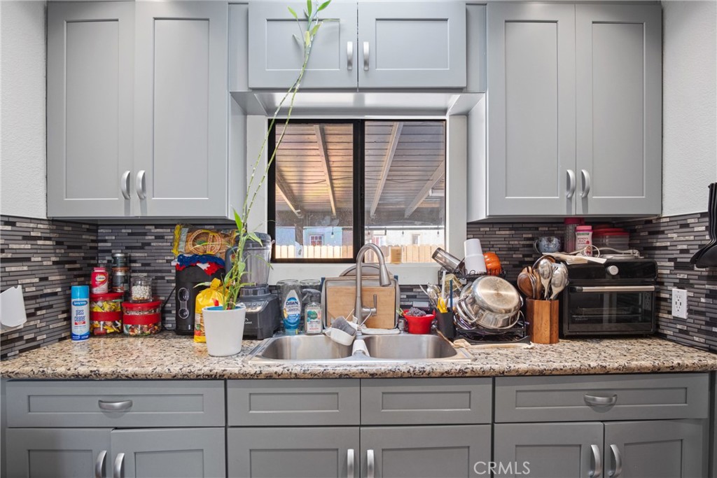 3420 Comer Avenue Riverside, CA 92507 - Photo 19 of 26 a kitchen with granite countertop a sink a stove and cabinets