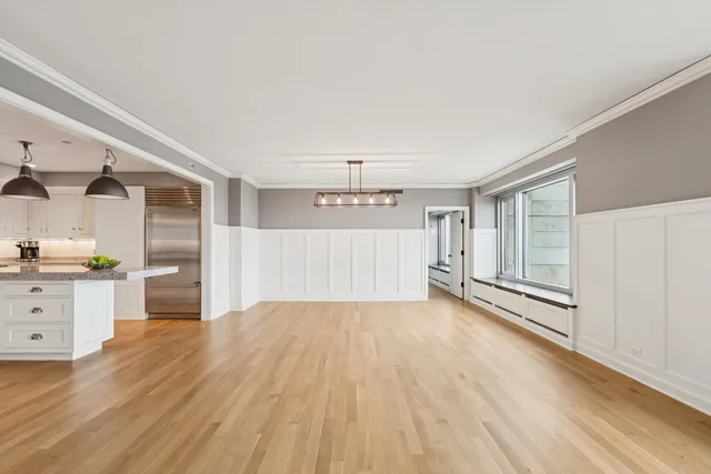 a view of a big room with wooden floor and windows