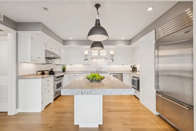 a kitchen with stainless steel appliances granite countertop a refrigerator a stove a sink and a granite counter tops