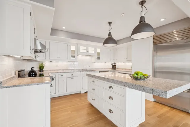 a kitchen with granite countertop white cabinets and white stove