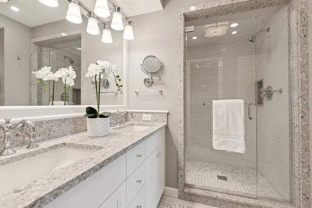 a bathroom with a granite countertop sink and a mirror