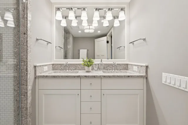 a bathroom with a granite countertop sink and a mirror