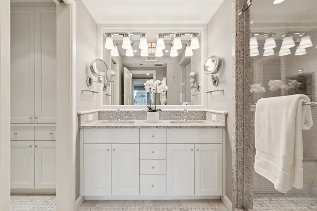 a bathroom with a sink a large mirror and shower