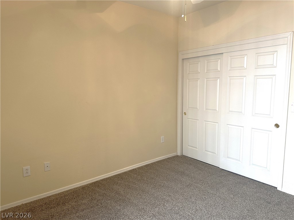 3034 Canal Walk Road Henderson, NV 89052 - Photo 7 of 24 This cozy bedroom features plush carpeting and a convenient closet, perfect for comfortable living.