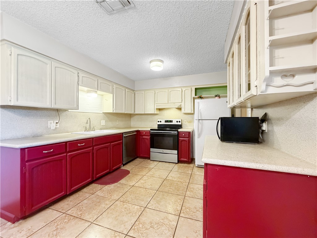 910 Twite Circle Corpus Christi, TX 78418 - Photo 13 of 40 a kitchen with stainless steel appliances kitchen island granite countertop a sink dishwasher stove top oven and cabinets