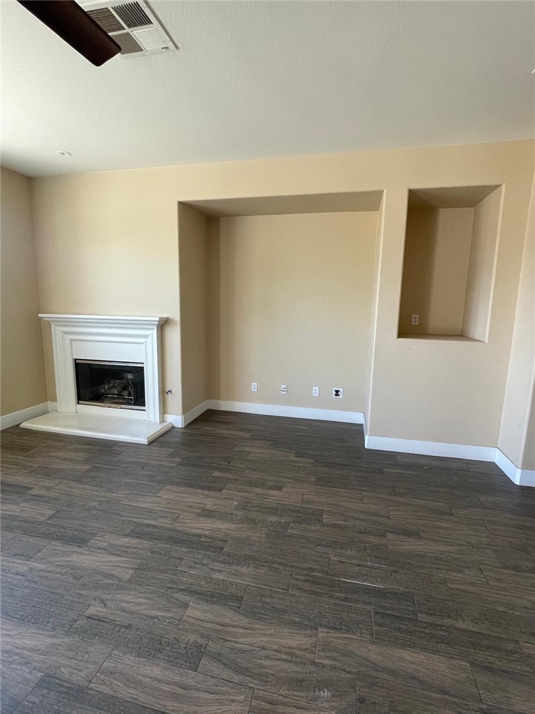 32689 Cottonwood Road Winchester, CA 92596 - Photo 19 of 25 a view of empty room with wooden floor and fireplace