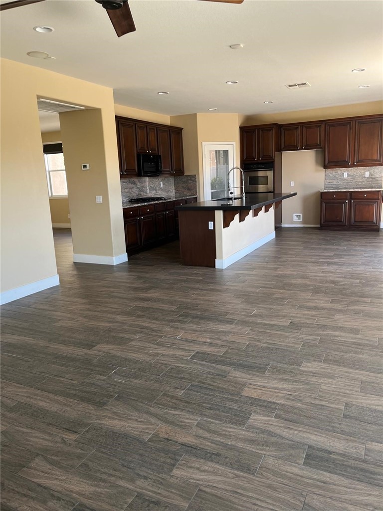 32689 Cottonwood Road Winchester, CA 92596 - Photo 10 of 25 a large kitchen with stainless steel appliances kitchen island a large counter top and a stove