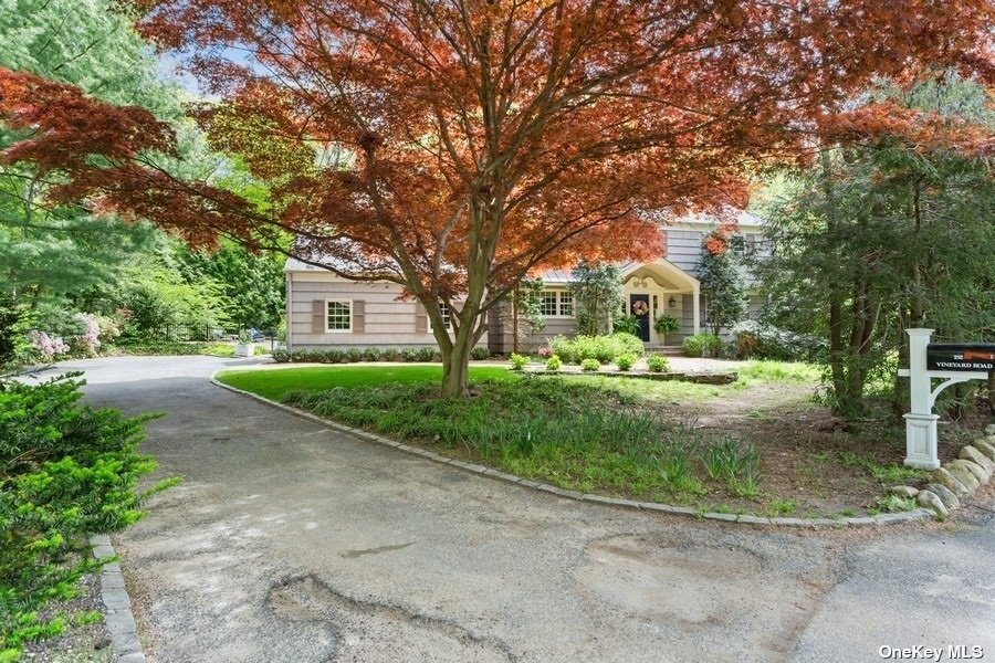 a front view of a house with a yard and green space