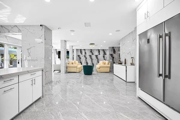 a kitchen with stainless steel appliances kitchen island granite countertop a refrigerator and microwave