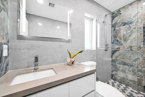 a white toilet sitting next to a bathroom sink