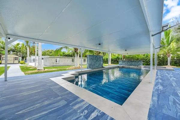 a front view of a house with swimming pool having outdoor seating