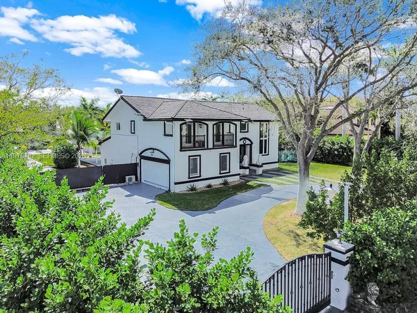 an aerial view of residential houses with outdoor space and trees