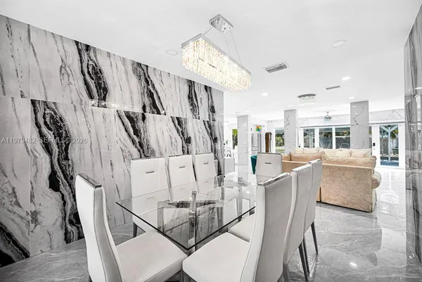 a large white kitchen with lots of counter space cabinets and stainless steel appliances