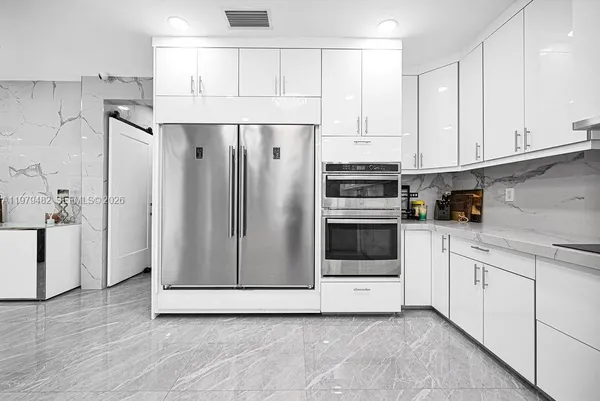 a kitchen with sink and white cabinets