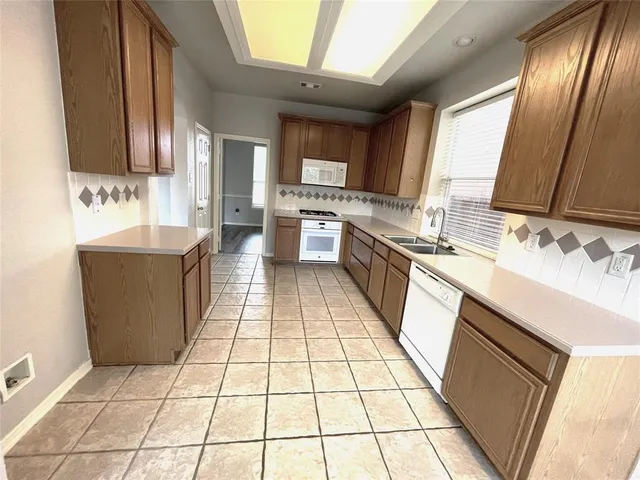 a large kitchen with stainless steel appliances a sink stove and cabinets