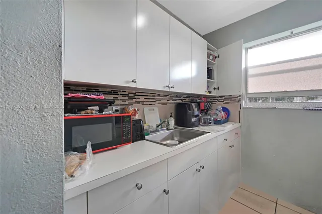 a kitchen with a stove a refrigerator and a window