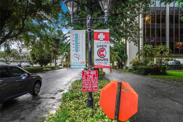 a sign that is sitting in the grass near a tree