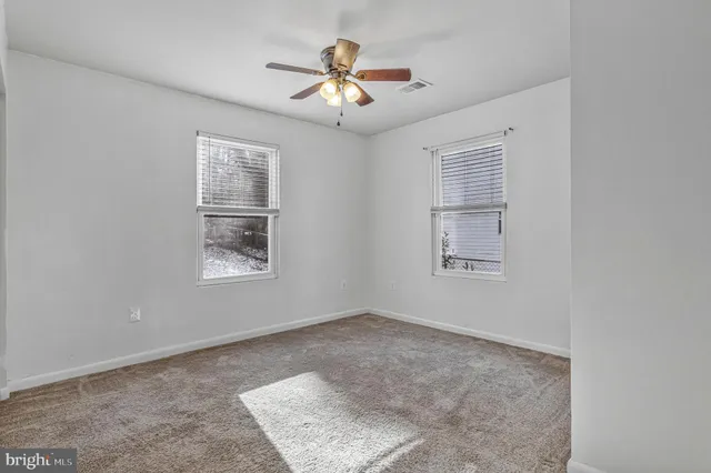 a view of a livingroom with a ceiling fan and window