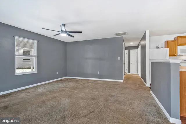 a view of a big room with windows and chandelier fan