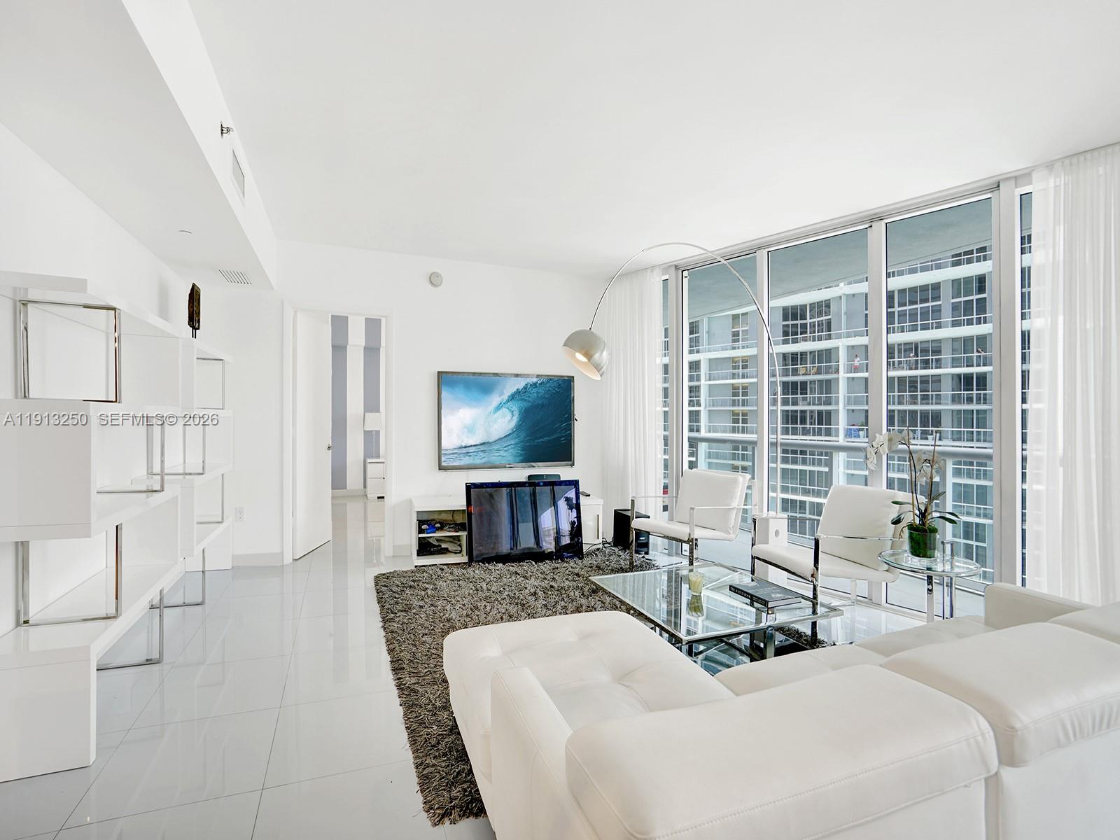 495 Brickell Avenue, Unit 2504 Miami, FL 33131 - Photo 11 of 28 a living room with furniture a large window and a flat screen tv